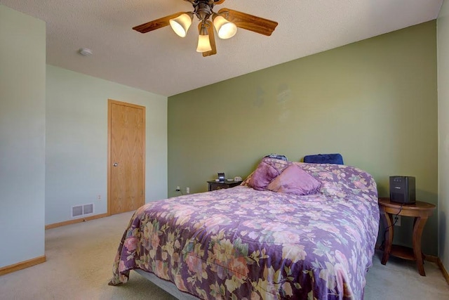 carpeted bedroom with baseboards, visible vents, and ceiling fan