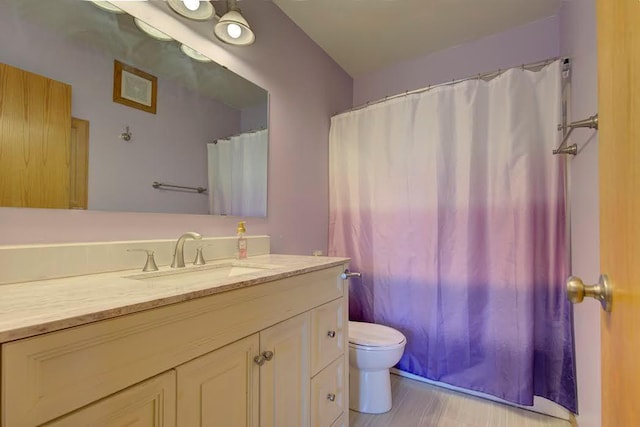 bathroom with vanity, curtained shower, toilet, and wood finished floors