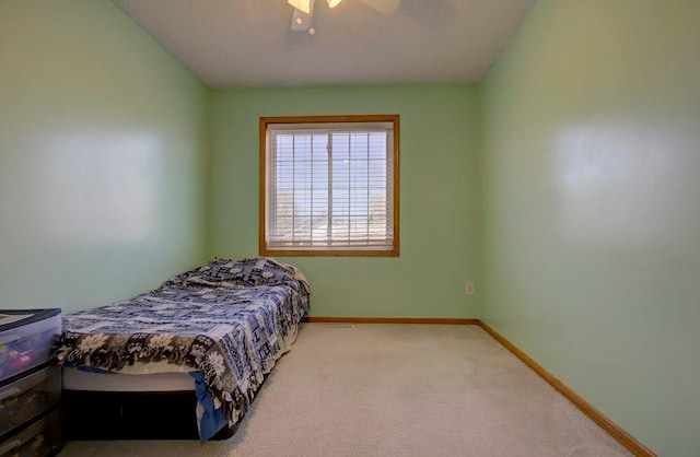 carpeted bedroom featuring a ceiling fan and baseboards
