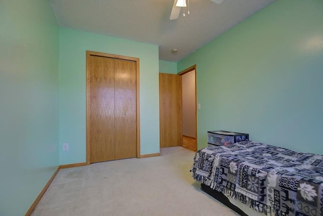 carpeted bedroom with baseboards, a ceiling fan, and a closet