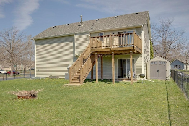 back of house featuring an outdoor structure, a deck, a fenced backyard, a shed, and a lawn