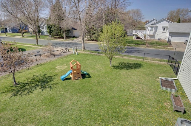view of home's community with a lawn, fence, playground community, and a residential view