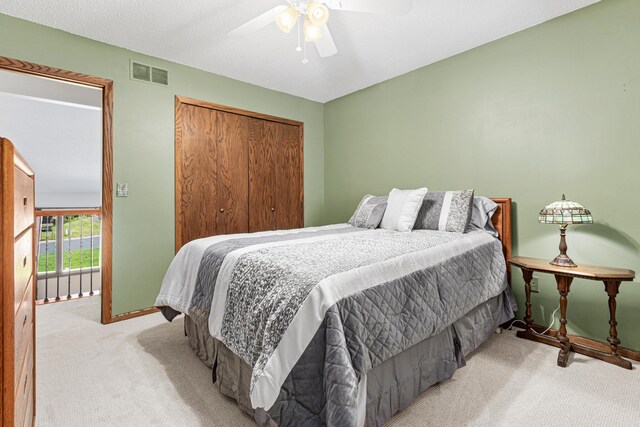 carpeted bedroom featuring a closet, baseboards, and ceiling fan