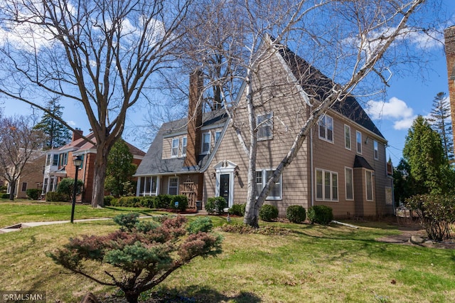 view of front of home with a front lawn and a chimney