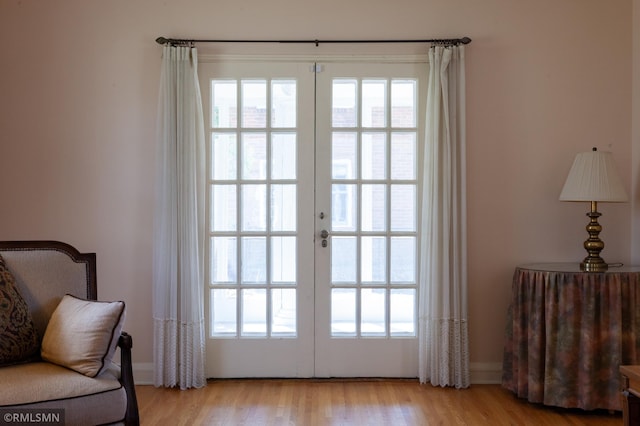 entryway with french doors, healthy amount of natural light, and light wood-type flooring