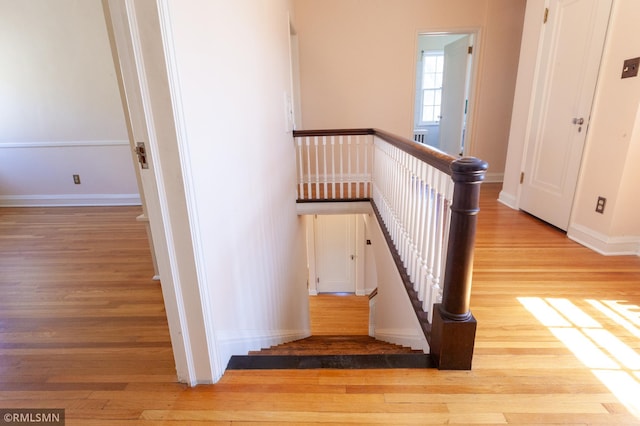 stairway featuring wood finished floors and baseboards