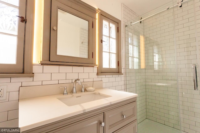 bathroom with a shower stall, vanity, and decorative backsplash