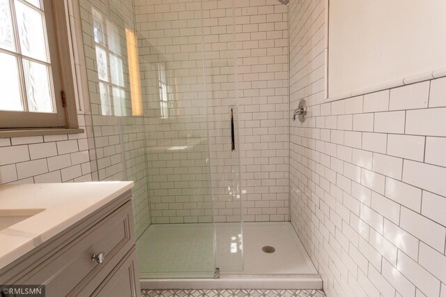 bathroom featuring tile walls, a shower stall, and vanity