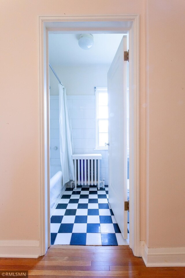 hallway featuring tile patterned floors and radiator heating unit