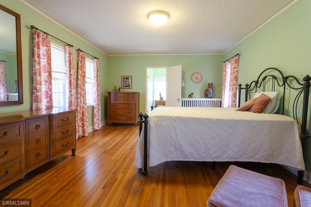 bedroom with crown molding and wood finished floors