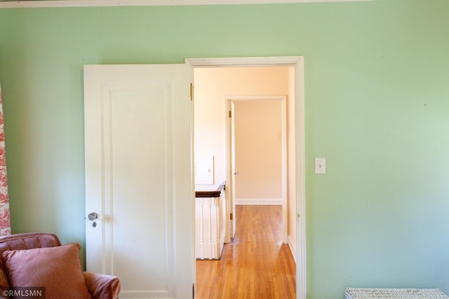 corridor with light wood finished floors and baseboards