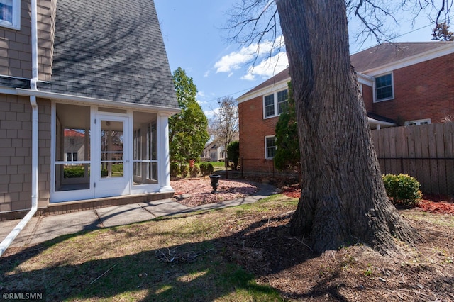 view of yard featuring fence and a sunroom