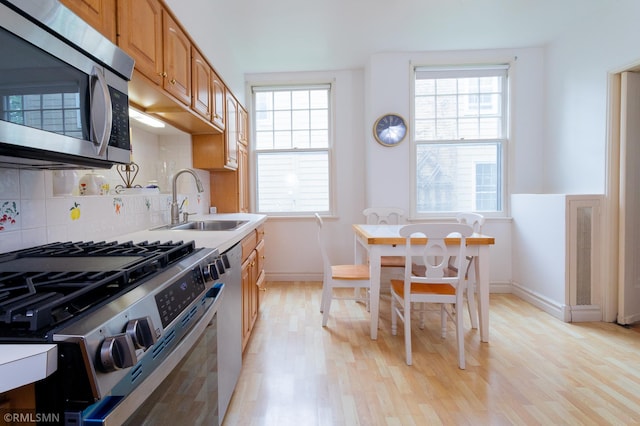 5128 Irving Ave S, Minneapolis, MN 55419 - kitchen featuring appliances with stainless steel finishes, light wood-style flooring, plenty of natural light, and a sink