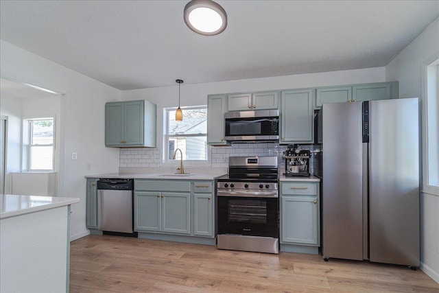 140 Carol Ln, West Saint Paul, MN 55118 - kitchen featuring light countertops, stainless steel appliances, light wood-style flooring, and a sink