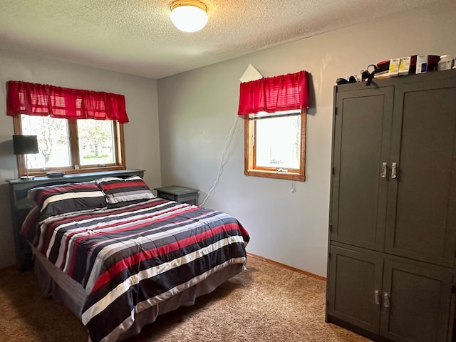 bedroom with carpet floors, a textured ceiling, and baseboards