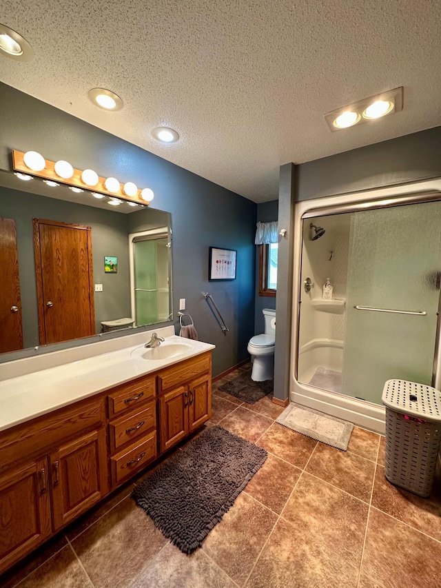 full bathroom with vanity, a textured ceiling, toilet, and a shower stall