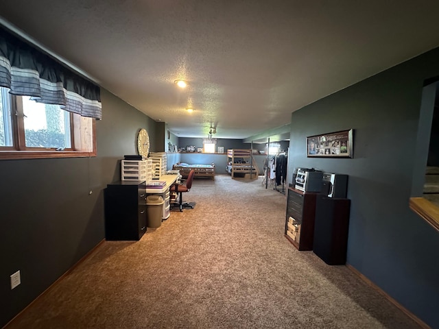 carpeted office featuring baseboards and a textured ceiling