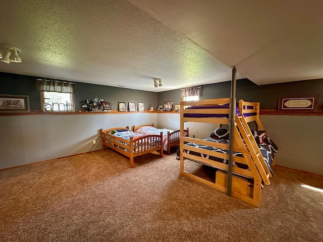 carpeted bedroom with a textured ceiling and multiple windows