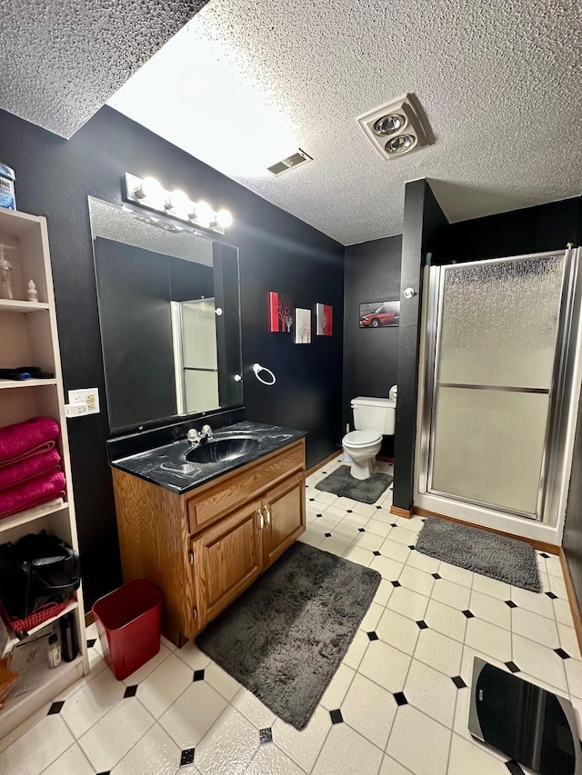 full bath featuring a textured ceiling, visible vents, a shower stall, vanity, and toilet