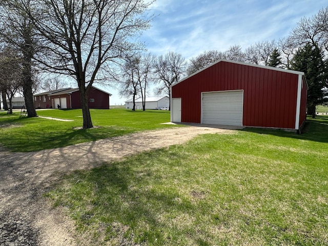 exterior space featuring a garage, dirt driveway, and an outdoor structure
