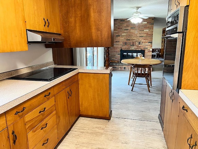 1313 Corbett Rd, Detroit Lakes, MN 56501 - kitchen with under cabinet range hood, ceiling fan, oven, and light countertops