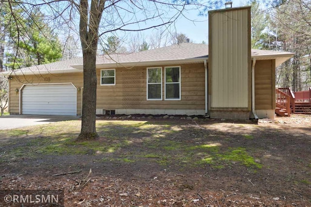 view of front of house featuring a garage, roof with shingles, driveway, and a chimney