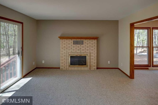 unfurnished living room featuring carpet floors, baseboards, and plenty of natural light