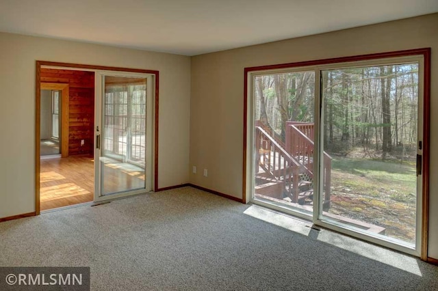 unfurnished room featuring carpet floors, baseboards, and visible vents