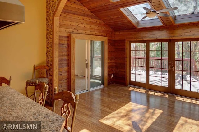 dining area featuring french doors, wood ceiling, wood finished floors, and wooden walls