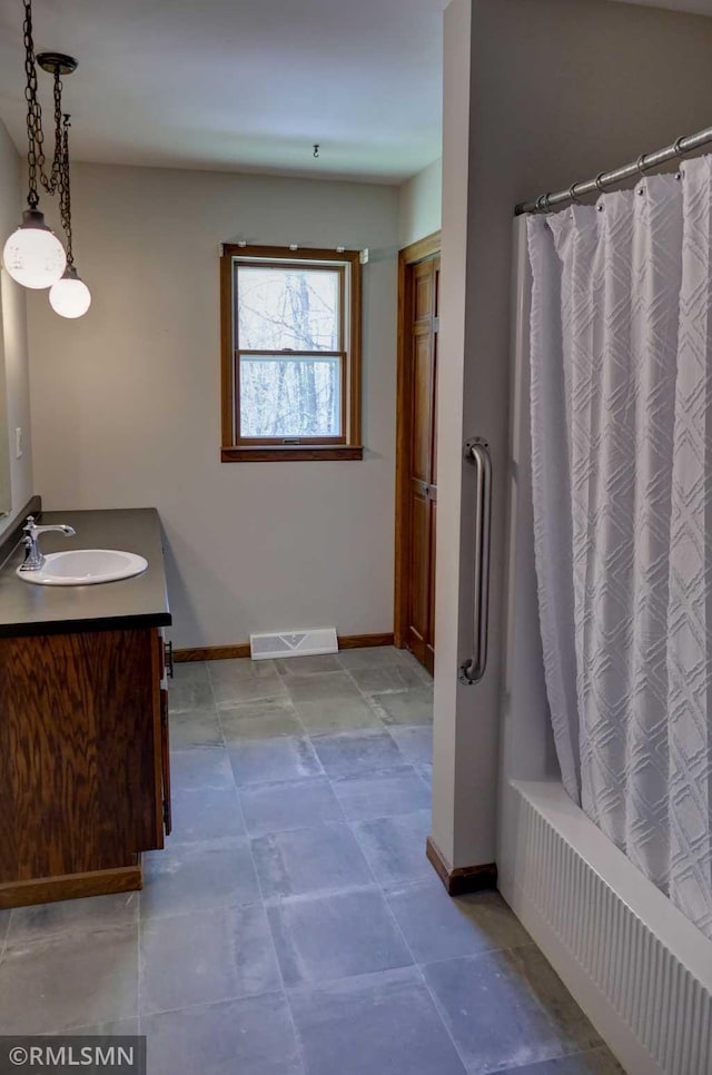 full bath featuring baseboards, shower / bath combination with curtain, vanity, and visible vents