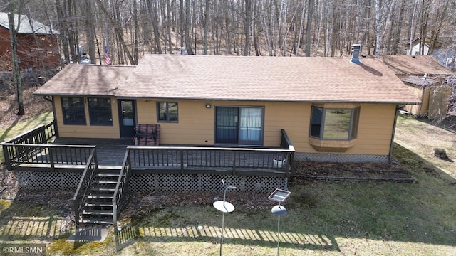 rear view of property with stairway, a deck, a chimney, and roof with shingles