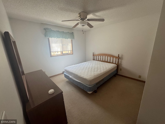 carpeted bedroom with baseboards, a ceiling fan, and a textured ceiling