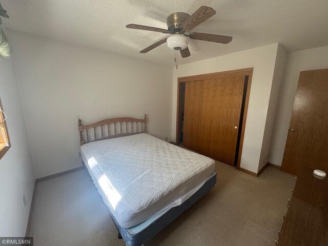 carpeted bedroom with a ceiling fan and a closet