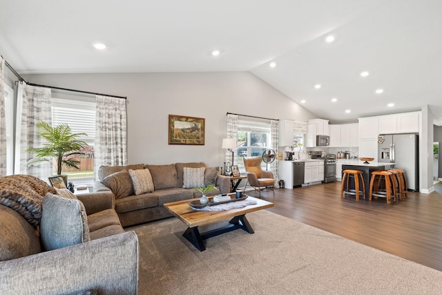 living area featuring dark wood-style floors, recessed lighting, and high vaulted ceiling