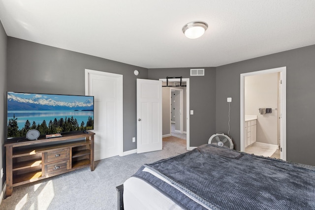 carpeted bedroom featuring a barn door, baseboards, and ensuite bathroom