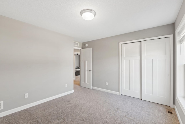 unfurnished bedroom with carpet floors, baseboards, and a closet
