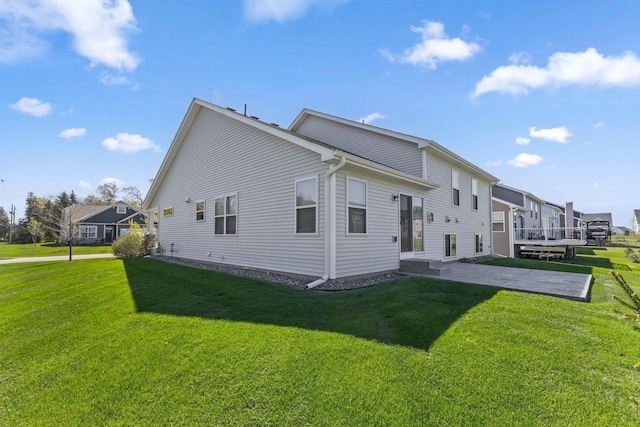rear view of property featuring a yard and a patio