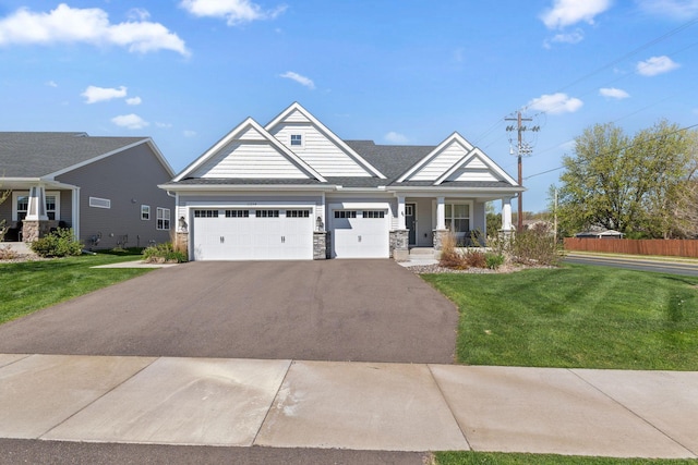 craftsman-style home with driveway, a porch, a garage, and stone siding