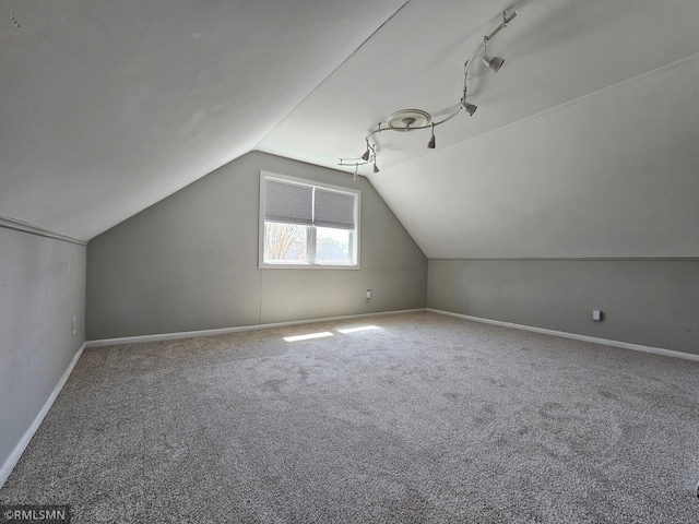 additional living space with carpet floors, baseboards, and vaulted ceiling