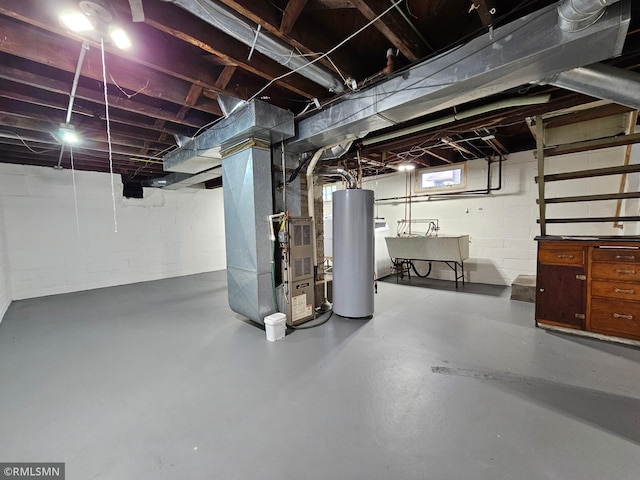 basement featuring a sink, concrete block wall, heating unit, and gas water heater