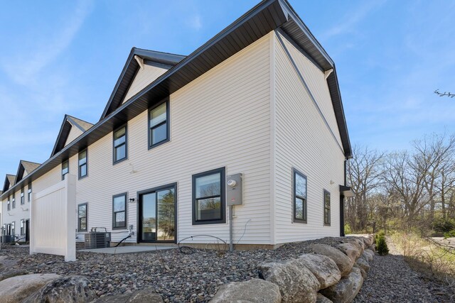 rear view of property featuring a patio and central air condition unit