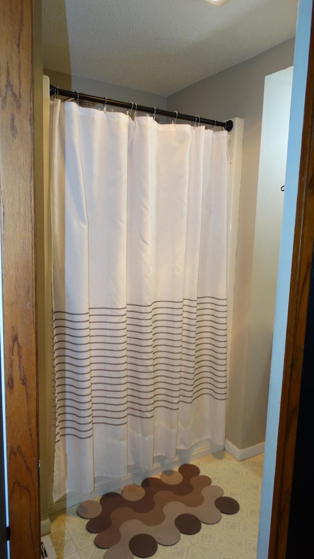 101 5th St, Cyrus, MN 56323 - bathroom with baseboards, a textured ceiling, curtained shower, and tile patterned floors