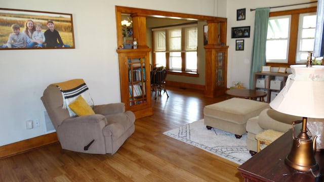 101 5th St, Cyrus, MN 56323 - living room with baseboards, ornate columns, wood finished floors, and visible vents