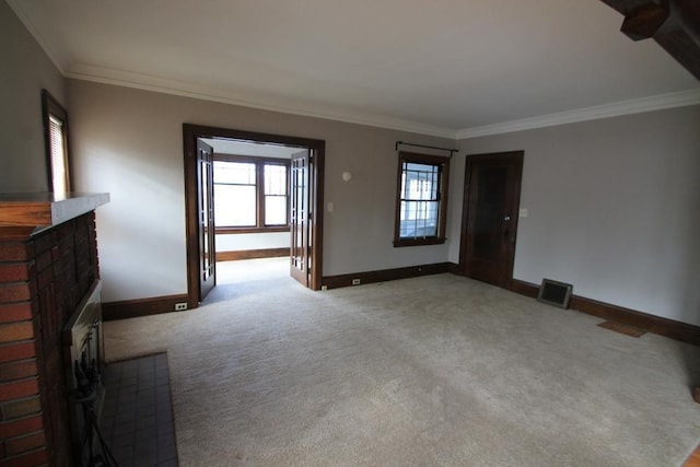 unfurnished living room featuring visible vents, crown molding, a fireplace, baseboards, and carpet flooring