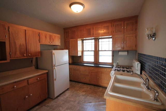 kitchen featuring a sink, brown cabinets, and white appliances