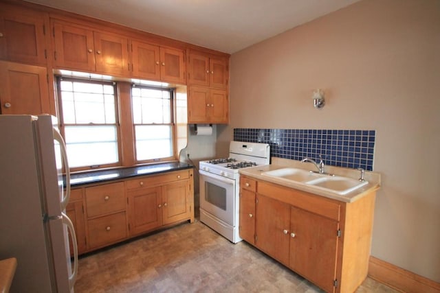 kitchen featuring a sink, brown cabinetry, and white appliances