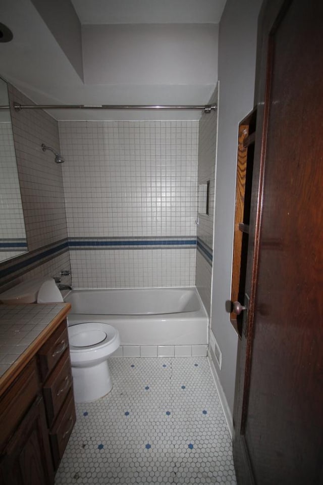 full bath featuring bathing tub / shower combination, tile patterned flooring, vanity, and toilet