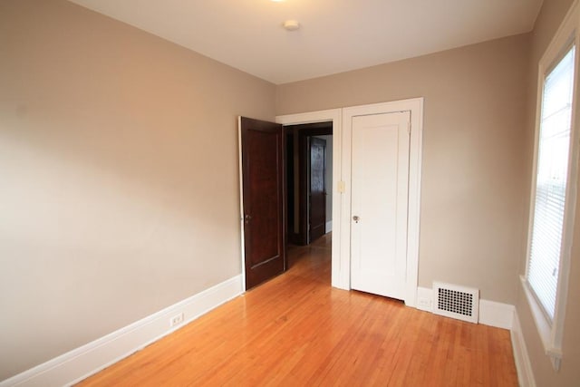 empty room with baseboards, visible vents, and light wood-style floors