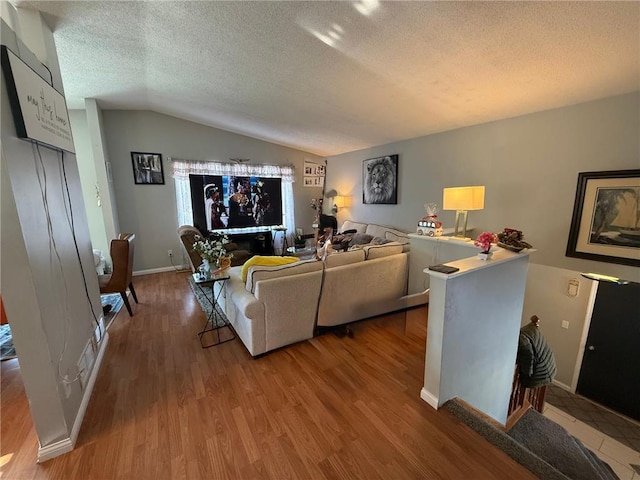 9007 Hampshire Ave N, Brooklyn Park, MN 55445 - living room with baseboards, a textured ceiling, wood finished floors, and vaulted ceiling