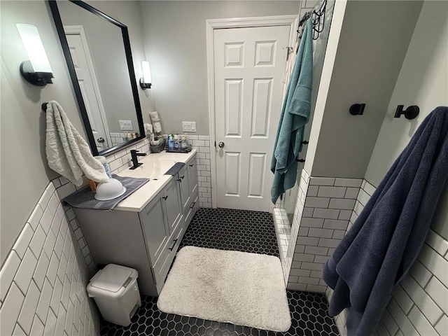 9007 Hampshire Ave N, Brooklyn Park, MN 55445 - bathroom with tile walls, a stall shower, wainscoting, vanity, and tile patterned floors